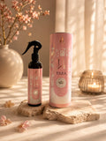 Parfum d'intérieur Yara 250 ml, vaporisateur et son tube rose posés sur travertin avec des fleurs de cerisier